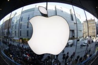 People wait on a street in front of an Apple store as they await sales of the new iPad in the Apple store in Munich in this file photo taken March 16, 2012.  Apple Inc has approved another $30 billion in share buybacks till the end of 2015 and authorized a rarely seen seven-for-one stock split, addressing calls to share more of its cash hoard while broadening the stock&#039;s appeal to individual investors.    REUTERS/Michaela Rehle/Files  (GERMANY - Tags: BUSINESS SCIENCE TECHNOLOGY)