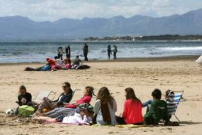 Varias personas intentan tomar ayer el sol en la Playa de Levante de Salou (Tarragona).