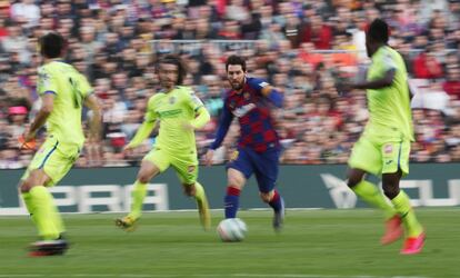 Messi controla el balón, rodeado por varios jugadores del Getafe. 