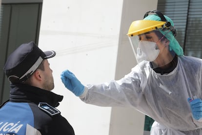 A health worker tests a police officer for the coronavirus in Madrid.