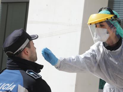 A health worker tests a police officer for Covid-19 in Madrid.