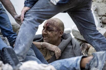 Un hombre es rescatado de entre los escombros tras el terremoto que ha tenido lugar en Amatrice.