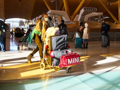Una mujer con un carro de maletas en el aeropuerto Adolfo Suárez, Madrid-Barajas, a 5 de enero de 2022.