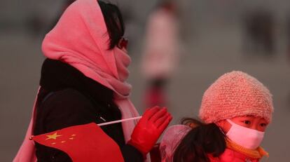 Una mujer y su hija, con mascarillas, cruzan la plaza de Tiananmen de Pekín el 30 de enero de este año.
