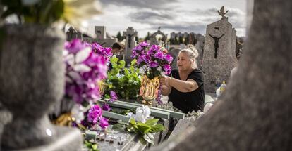 Esmeralda, de la familia Maya de la Rosa, preparando la decoracion floral en la tumba de sus familiares en el cementerio de La Almudena de Madrid