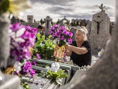 Esmeralda, de la familia Maya de la Rosa, preparando la decoracion floral en la tumba de sus familiares en el cementerio de La Almudena de Madrid