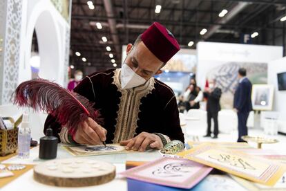 Un calígrafo estampa en cartulina el nombre de un vistante de Fitur en el estand de Marruecos.