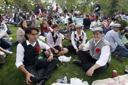 Decenas de personas vestidas de chulapos pasan el día de San Isidro en la pradera del patrón.