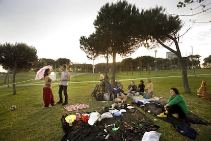 Unos jóvenes hacen un picnic en el césped del parque del Diagonal Mar (Litoral), en Barcelona.