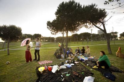 Unos jóvenes hacen un picnic en el césped del parque del Diagonal Mar (Litoral), en Barcelona.