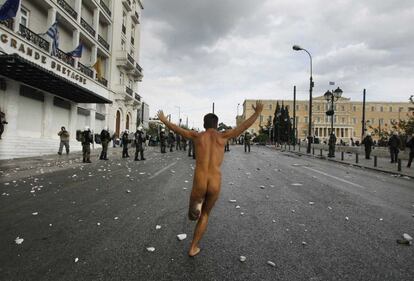 Un manifestante se lanza desnudo hacia las posiciones de la policías.