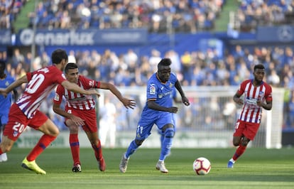 Amath del Getafe corre rodeado de jugadores del Atlético de Madrid.