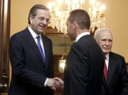 El primer ministro griego, Antonis Samarás (i), saluda al nuevo ministro de Finanzas, Yiannnis Stournaras. EFE/Archivo