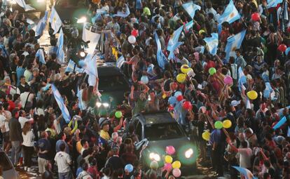 Seguidores del presidente electo Mauricio Macri celebran la victoria con banderas argentinas en una calle cerca del emblemático Obelisco.