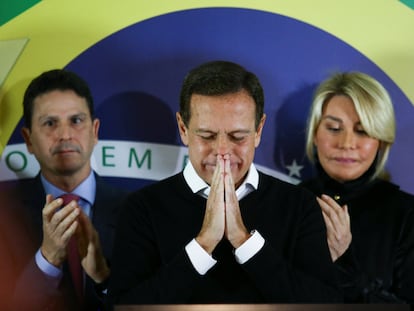 El exgobernador João Doria, tras anunciar su renuncia este lunes flanqueado por el presidente de su partido y por su esposa.