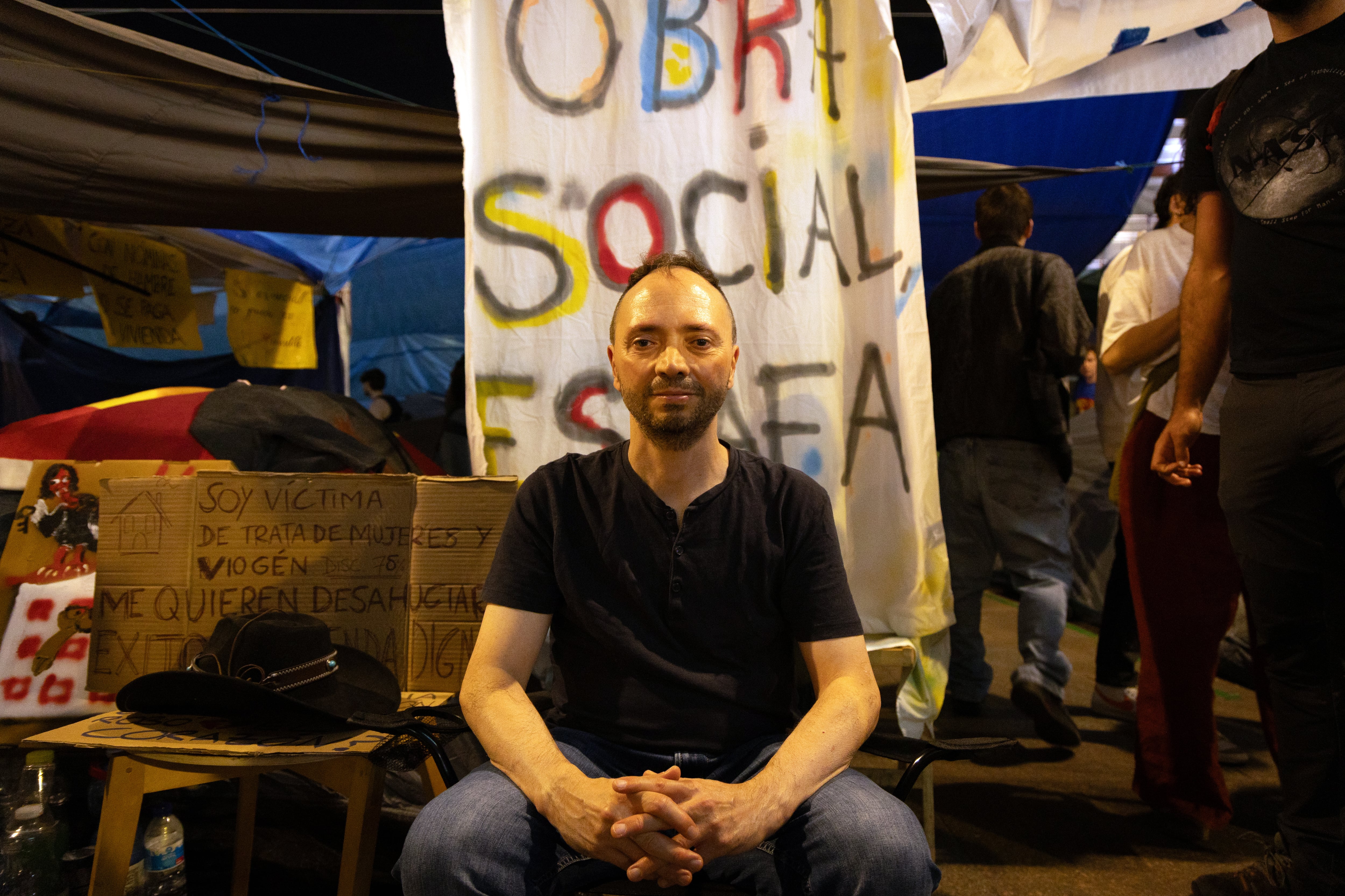 David Jímenez posa en la acampada de Sol con la pancarta que colgó del balcón de su casa durante un año, el pasado miércoles. 