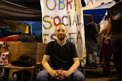 David Jímenez posa en la acampada de Sol con la pancarta que colgó del balcón de su casa durante un año, el pasado miércoles. VICTORIA GARCIA