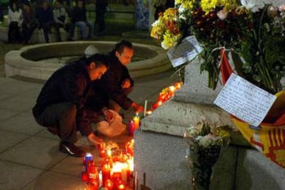 Dos ciudadanos encienden velas en recuerdo del Papa en la catedral de la Almudena de Madrid.