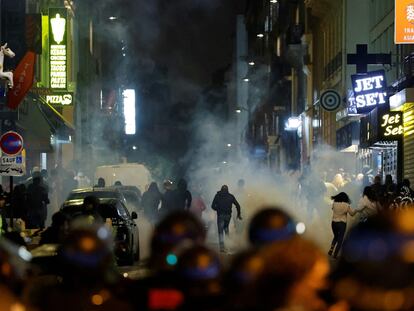 Varios manifestantes huyen de los policías franceses que usan gases lacrimógenos en París el pasado domingo.