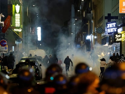 Varios manifestantes huyen de los policías franceses que usan gases lacrimógenos en París el pasado domingo.