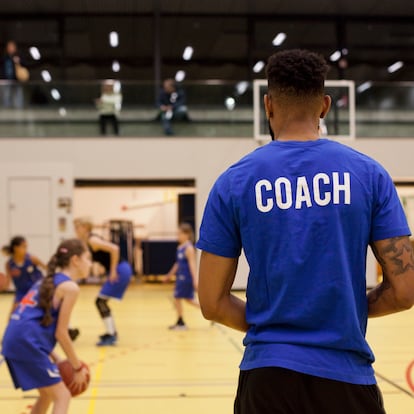 Coach training girls' basketball team, focus on him