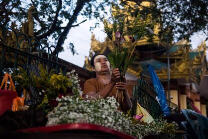 Una mujer vende flores a los turistas que visitan Ye Le Pagoda, un templo budista construido en mitad del río de Yangon, en Birmania, el 17 de abril de 2017.