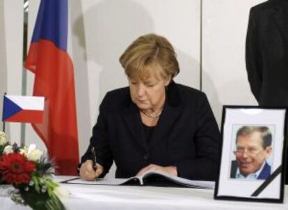 La canciller alemana Ángela Merkel firma en el libro de condolencias por el expresidente checo Vaclav Havel.