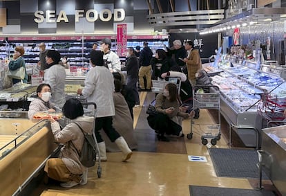 Varios clientes de un supermercado se agachan tras sentir una sacudida durante el terremoto en un supermercado de la ciudad de Toyama, en la prefectura del mismo nombre, este lunes. 