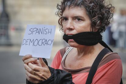 Una dona emmordassada subjecta un missatge que diu "la democràcia espanyola", en protesta per l'empresonament de Cuixart i Sànchez.