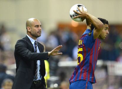 Guardiola da instrucciones a Marc Bartra durante un saque de banda.