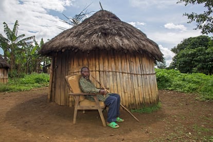 La mayoría de las casas de estas aldeas tienen forma redonda y se construyen con madera procedente del bosque. Un hombre sentado a la sombra de su cabaña.