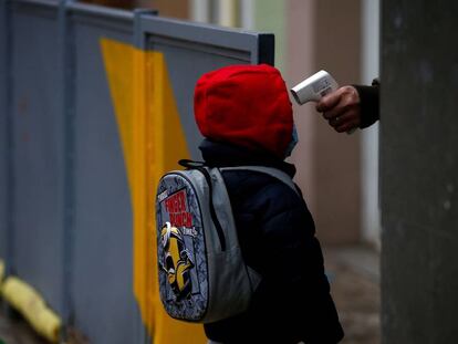 Una professora pren la temperatura a un alumne a l'escola Rubén Dario de Barcelona.