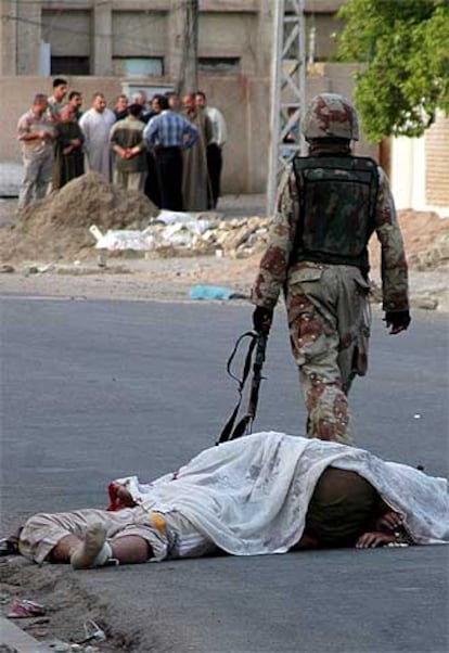 Un soldado iraquí pasa delante de unos cuerpos hallados ayer en Bagdad.