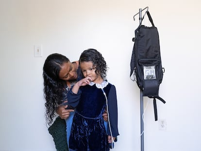 Deysi Vargas y su hija Sofía con la mochila que le proporciona medicamento, en California, el 21 de mayo.