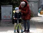 A woman wipes the face of a child on the streets of Beijing on Thursday, March 12, 2020. For most people, the new coronavirus causes only mild or moderate symptoms. For some it can cause more severe illness, especially in older adults and people with existing health problems. (AP Photo/Ng Han Guan)