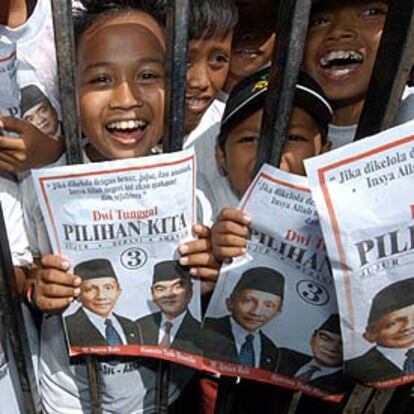 Niños indonesios muestran carteles de dos candidatos en Makassar.