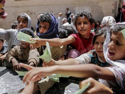 Un grupo de niños presenta documentos a una ONG local para recibir su ración de comida, en abril de 2017 en Saná.