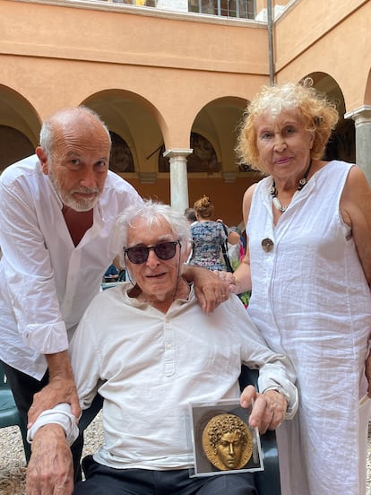 Imagen cedida por Agustín de Celis, en el centro, que sostiene una medalla conmemorativa del 150º aniversario de la Academia de España en Roma. Le acompañan en la sede de la institución su esposa, Miranda D’Amico, escultora y poeta que fue también becaria en la Academia, y el arquitecto y escultor Juan Bordes, igualmente antiguo becario.