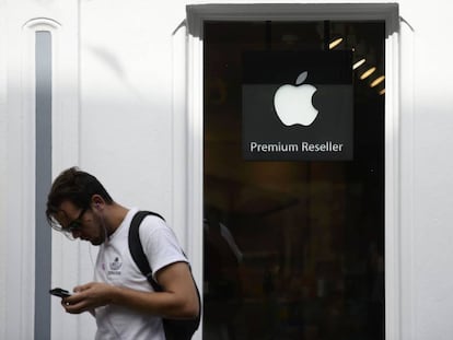 Un hombre consulta su m&oacute;vil delante de una tienda de Apple en Galway, Irlanda.