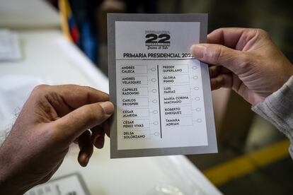 Un ciudadano muestra el cartón de votación que utilizó para votar.