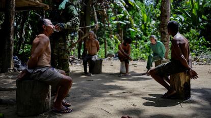 Un inspector ambiental del Ibama da de beber a un minero furtivo ante otros detenidon, en diciembre de 2023, en la Tierra Indígena Yanomami.