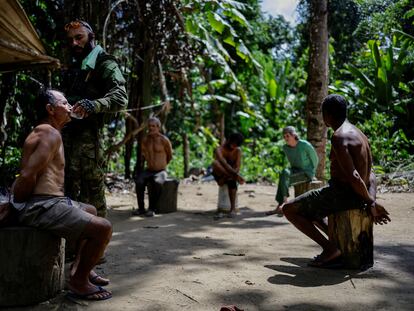 Un inspector ambiental del Ibama da de beber a un minero furtivo ante otros detenidon, en diciembre de 2023, en la Tierra Indígena Yanomami.