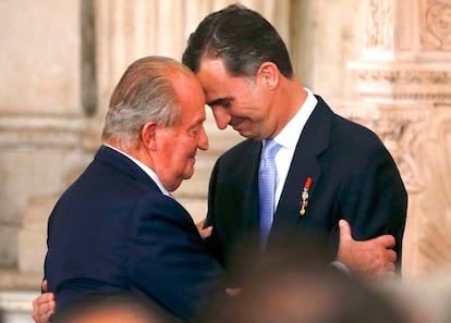 Don Juan Carlos abraza a su hijo Felipe, tras la sanción de la ley de abdicación y la cesión simbólica de su sillón a su hijo, en una ceremonia en el Palacio Real de Madrid.  Juan Carlos I abdicaba tras 39 años de reinado como consecuencia de sus escándalos públicos y privados. 