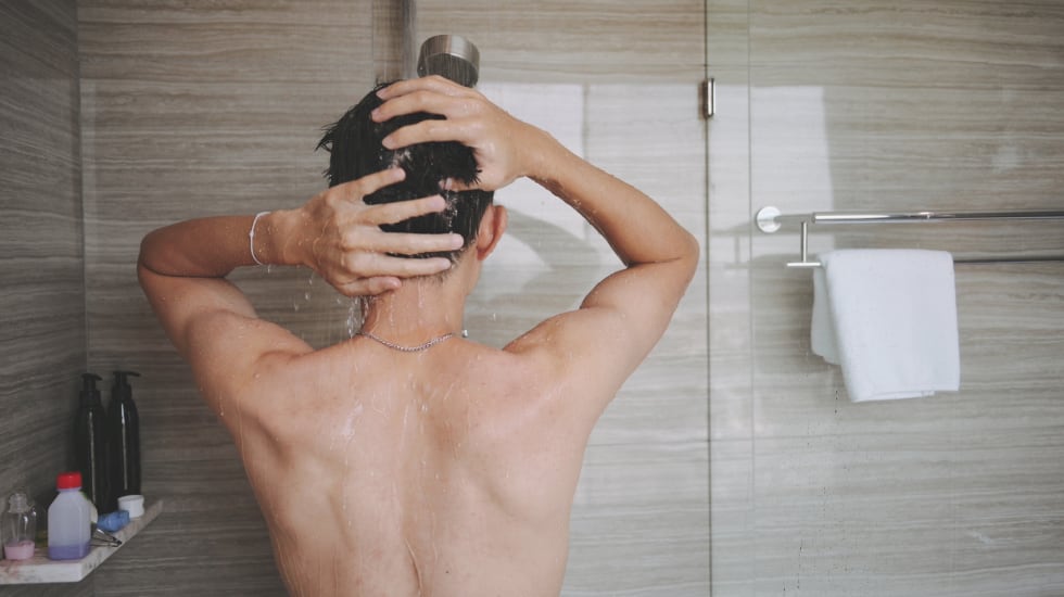 Una persona se aclara el cabello con abundante agua.