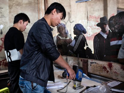 Un hombre chino prueba la pureza del cobalto en el mercado de Musompo, en las afueras de Kolwezi (Congo).