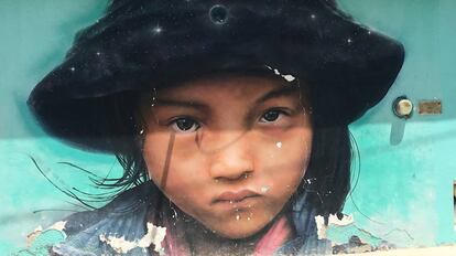 Pintada de una niña sobre un muro.