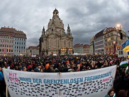 Manifestaci&oacute;n por la convivencia frente a la Frauenkirche de Dresde con un cartel que dice &quot;Muro de la amistad sin fronteras&quot;.
