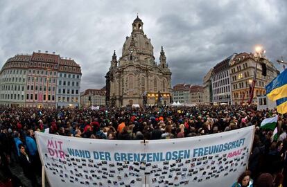 Manifestaci&oacute;n por la convivencia frente a la Frauenkirche de Dresde con un cartel que dice &quot;Muro de la amistad sin fronteras&quot;.