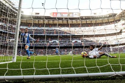  El delantero del Deportivo Adrián López (i) lanza marcando gol ante el defensa brasileño del Real Madrid, Marcelo Vieira (d).