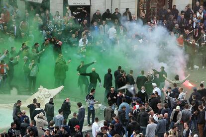 Los ultras prenden varios botes de humo en la Plaza de España.